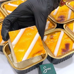 Quy trình đóng gói bánh sữa chua nướng Sari Bakery trong hộp nhôm tiện lợi.